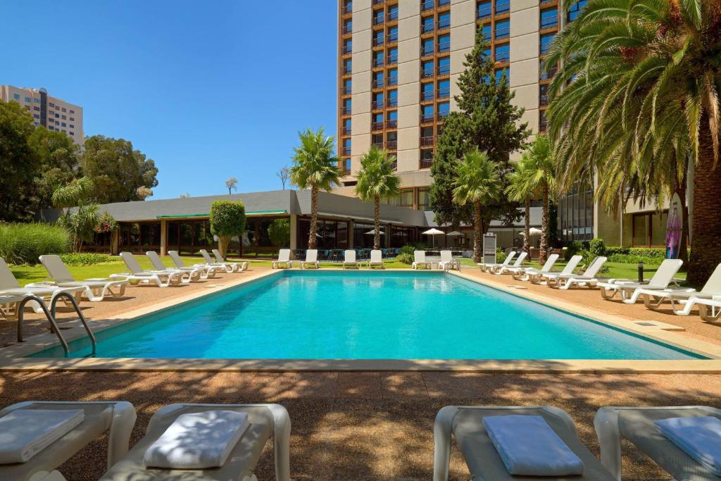einen Pool mit Liegestühlen und ein Hotel in der Unterkunft Lisbon Marriott Hotel in Lissabon