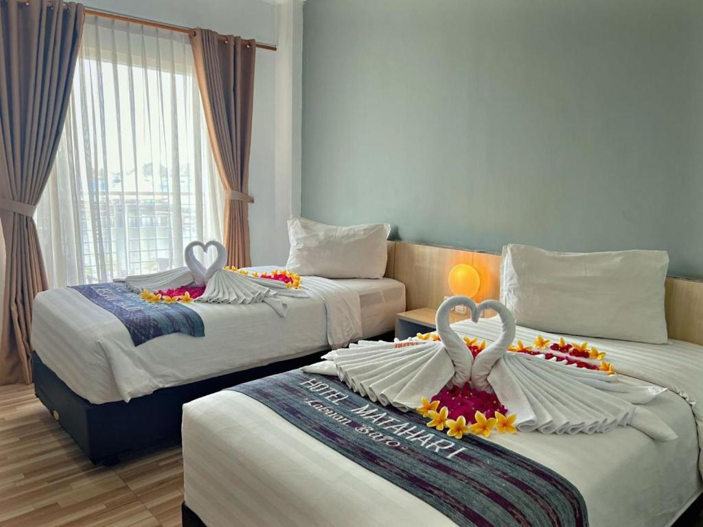 מיטה או מיטות בחדר ב-Matahari Hotel Labuan Bajo