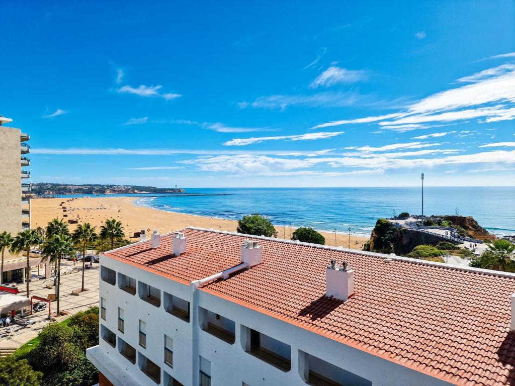 ein Blick auf den Strand vom Balkon eines Gebäudes in der Unterkunft Apartment Concorde Sky Vista Mar in Portimão