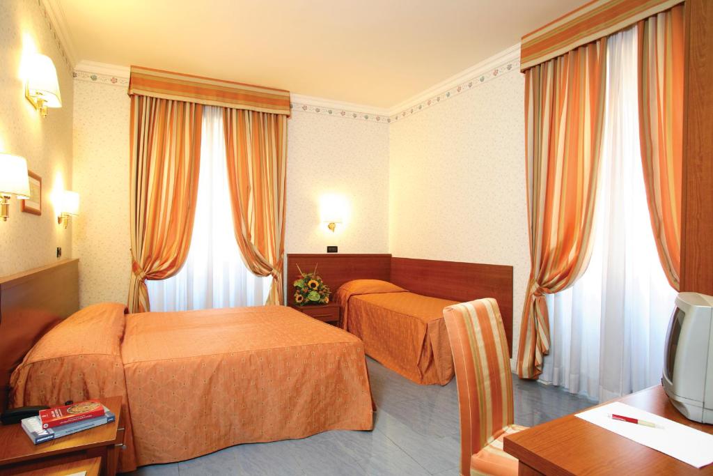 ローマにあるホテル ディナのベッド2台とテレビが備わるホテルルームです。