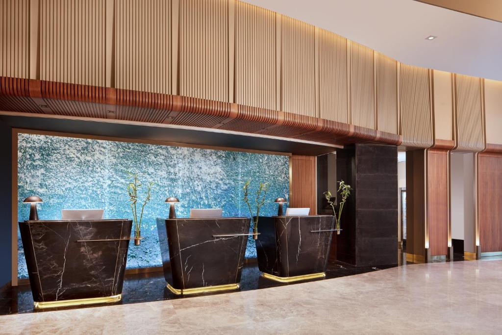 a lobby with a row of tables with plants at Delta Hotels by Marriott Istanbul Levent in Istanbul