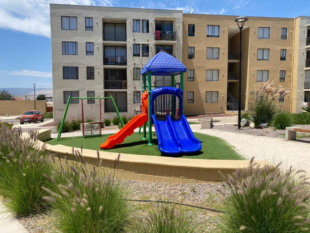un parque infantil frente a un edificio de apartamentos en Departamentos Caldera Suites, en Caldera