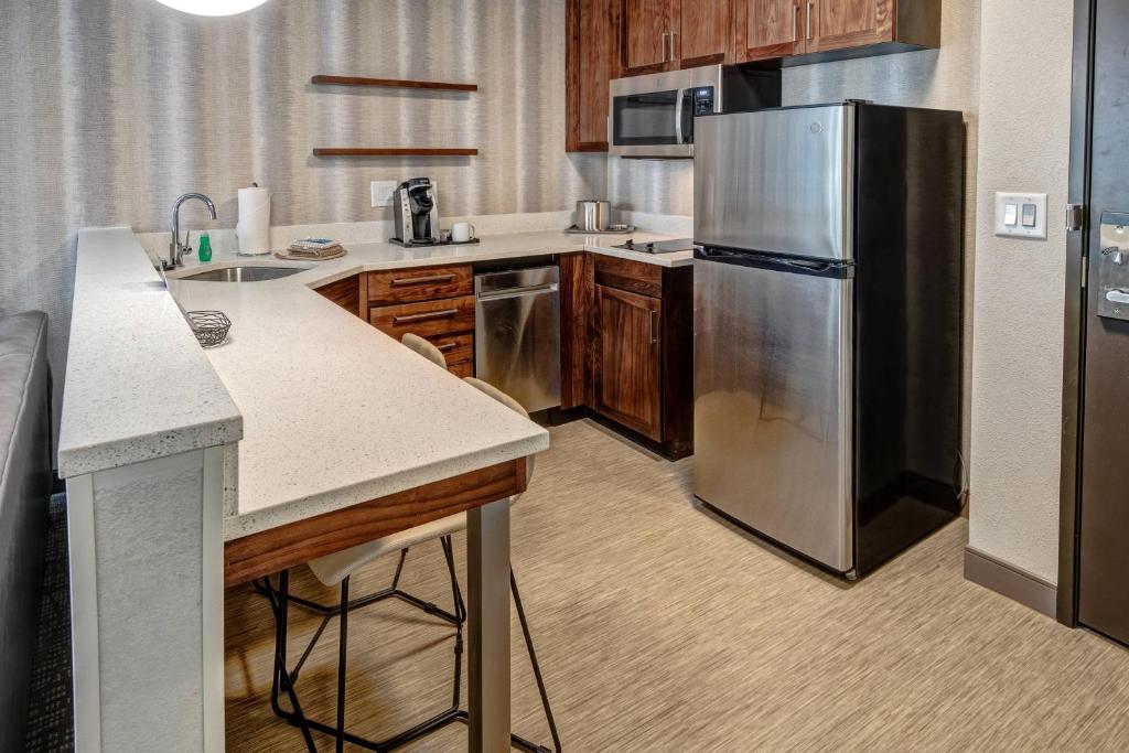 a kitchen with a stainless steel refrigerator and wooden cabinets at Residence Inn by Marriott Nashville Green Hills in Nashville