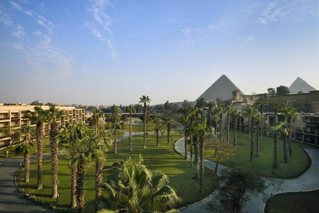 una vista aérea de un complejo con palmeras y pirámides en Marriott Mena House, Cairo en El Cairo