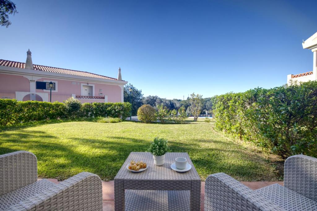 a patio with a table and chairs in a yard at Cegonha Country Club in Vilamoura