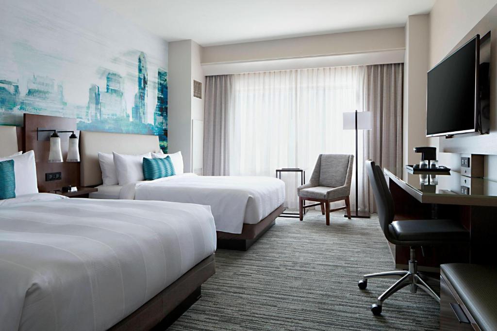 a hotel room with two beds and a desk at Indianapolis Marriott Downtown in Indianapolis