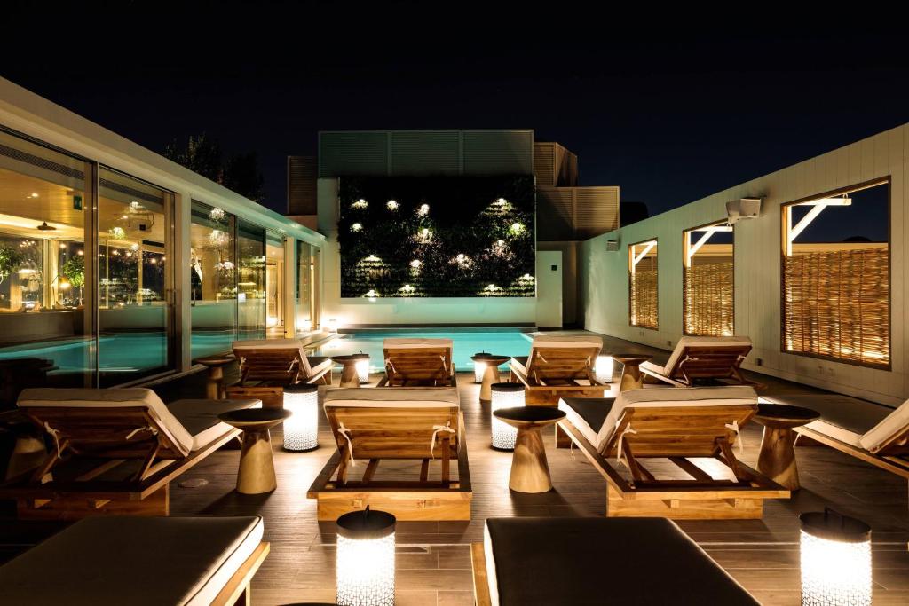 a patio with chairs and tables at night at Athens Marriott Hotel in Athens