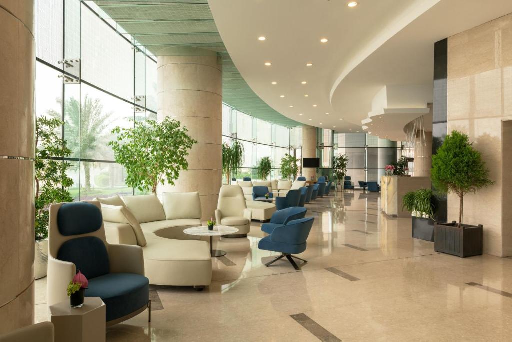 a lobby with couches and chairs in a building at Four Points By Sheraton Kuwait in Kuwait