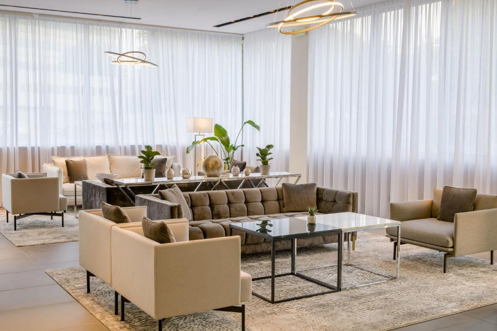 uma sala de estar com um sofá, cadeiras e uma mesa em AC Hotel by Marriott Milan Sesto em Sesto San Giovanni