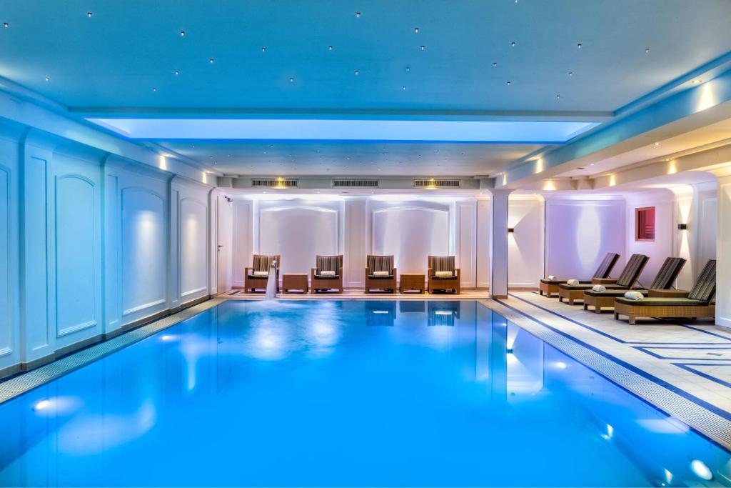 ein großer Pool in einem Gebäude mit Stühlen in der Unterkunft JW Marriott Hotel Berlin in Berlin
