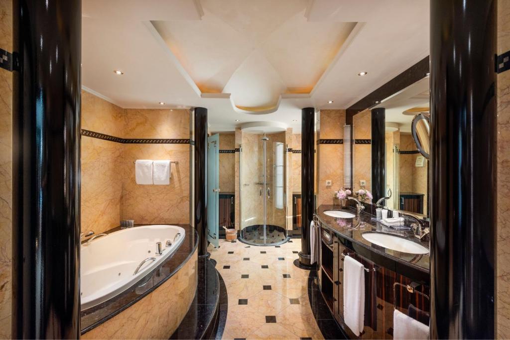 ein Badezimmer mit zwei Waschbecken und einer Badewanne in der Unterkunft JW Marriott Hotel Berlin in Berlin