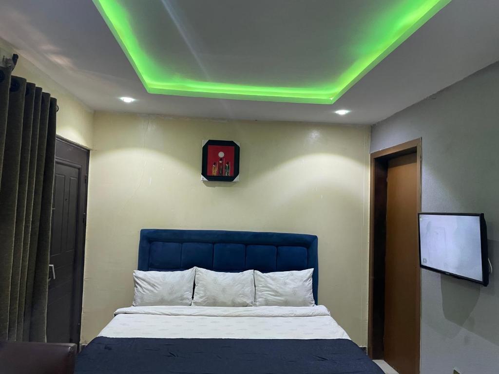 a bedroom with a bed with a green ceiling at Suite Subzero in Lagos