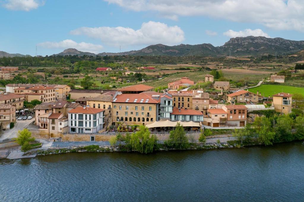 un groupe de bâtiments à côté d'une masse d'eau dans l'établissement Palacio Tondón, La Rioja Brinas, Autograph Collection, à Briñas