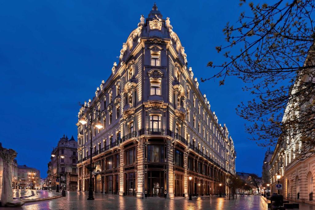 ein großes Gebäude mit einer Uhr darüber in der Unterkunft Matild Palace, a Luxury Collection Hotel in Budapest