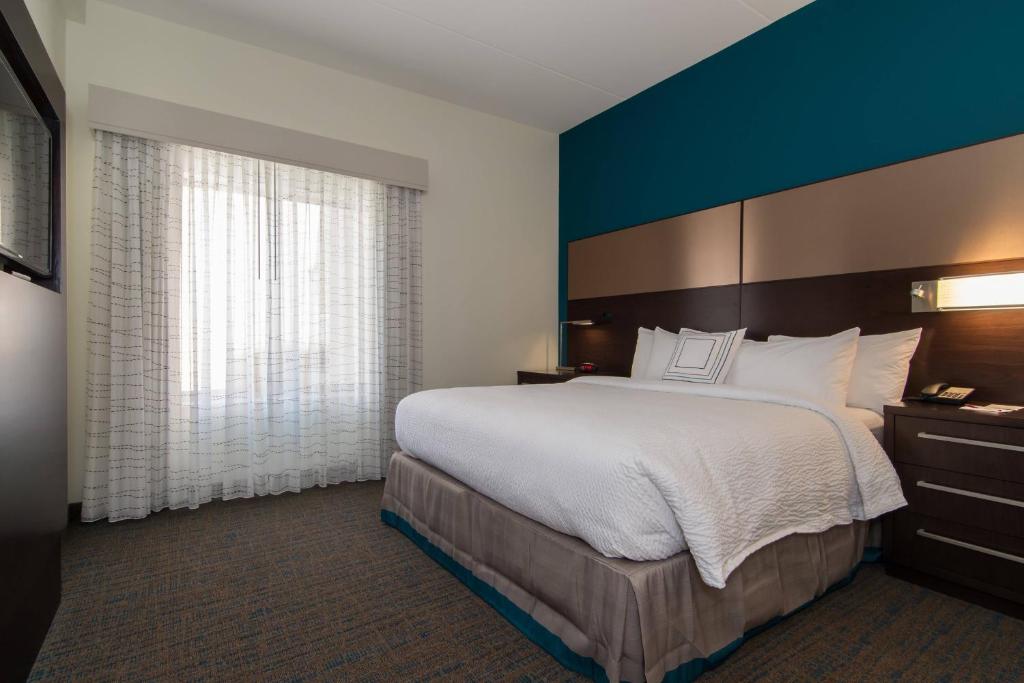 a bedroom with a large bed and a blue wall at Residence Inn Raleigh-Durham Airport/Brier Creek in Raleigh