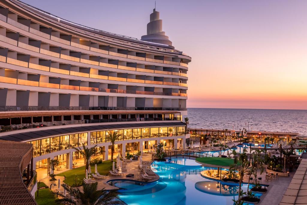 a hotel with a pool and the ocean in the background at Seaden Quality Resort & Spa Ultra All Inclusive in Side