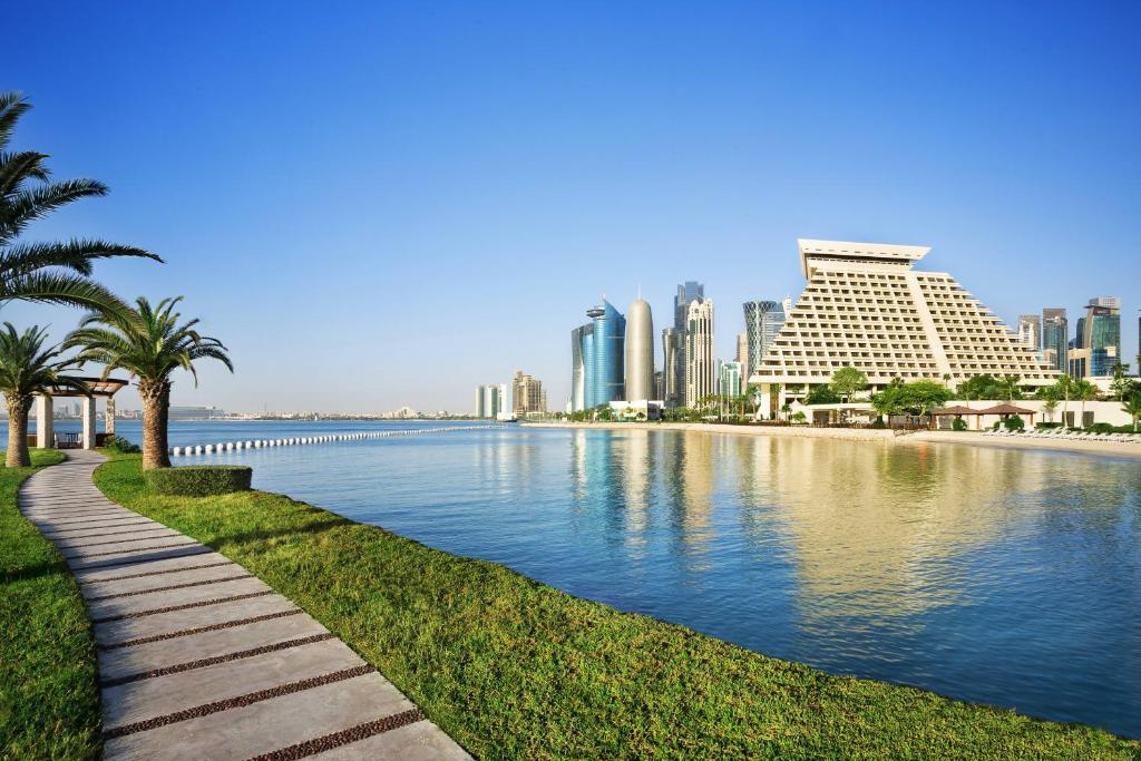 منتجع ومركز اجتماعات شيراتون الدوحة  في الدوحة: نهر في مدينة بها مباني و نخيل