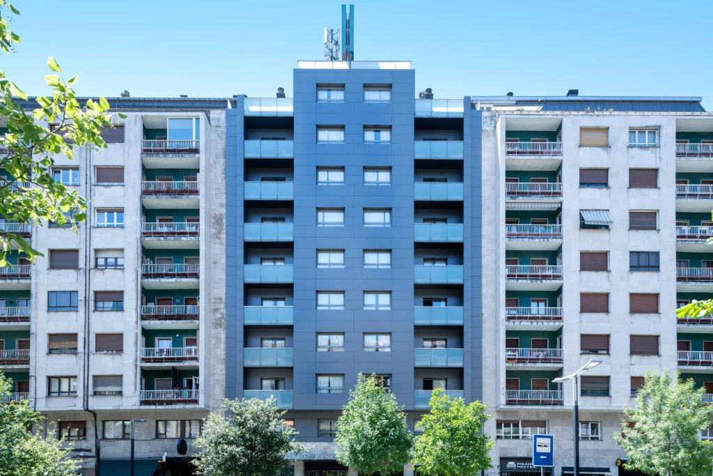 um prédio de apartamentos com árvores em frente em B&B HOTEL Vitoria General Álava em Vitoria-Gasteiz