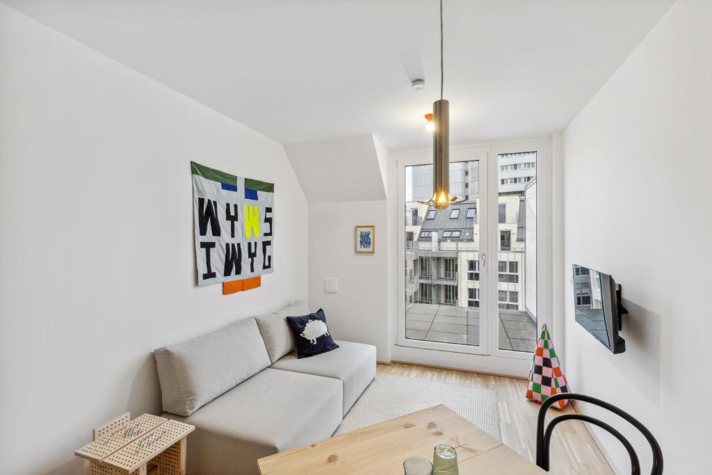 een woonkamer met een bank en een tafel bij Arbio I Ding Design Apartments in Brigittenau Vienna in Wenen