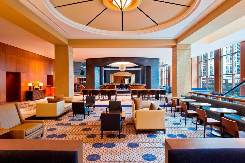eine Hotellobby mit Tischen und Stühlen und ein Restaurant in der Unterkunft Sheraton Grand Chicago Riverwalk in Chicago