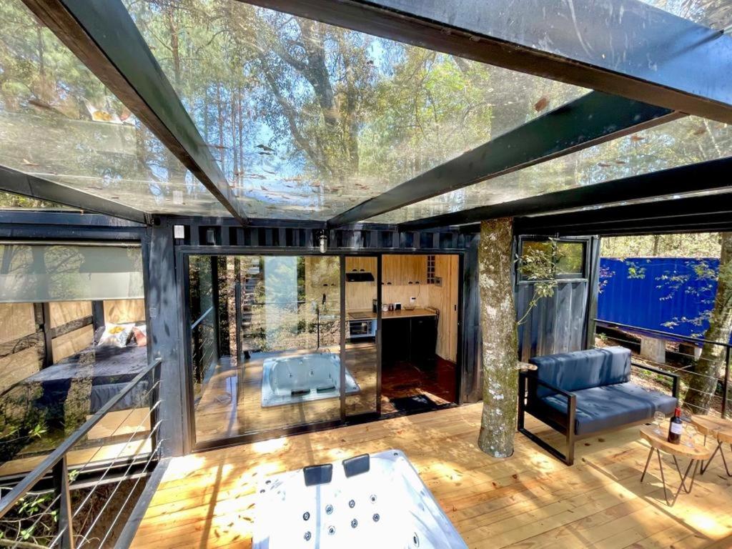 a glass house with a view of the living room at ZACATLAN CONTENEDORES in Tomatlán