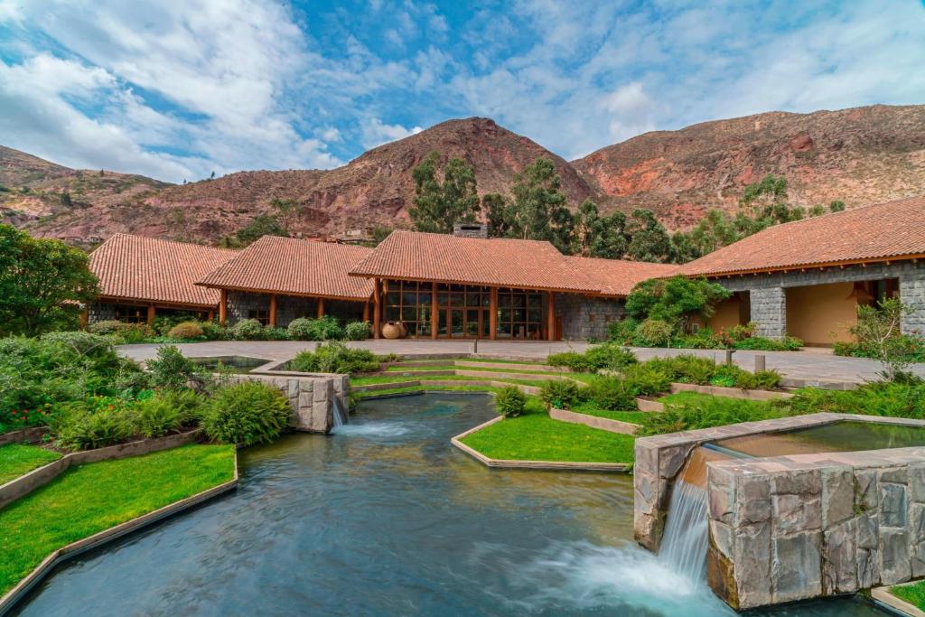 ein Haus mit einem Wasserfall in der Mitte eines Flusses in der Unterkunft Tambo del Inka, a Luxury Collection Resort & Spa, Valle Sagrado in Urubamba