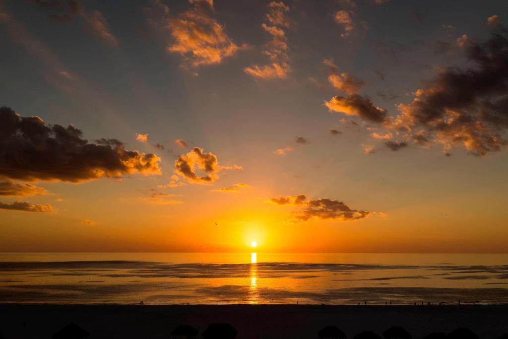 a sunset on the beach with the sun in the sky at JW Marriott Marco Island Beach Resort in Marco Island