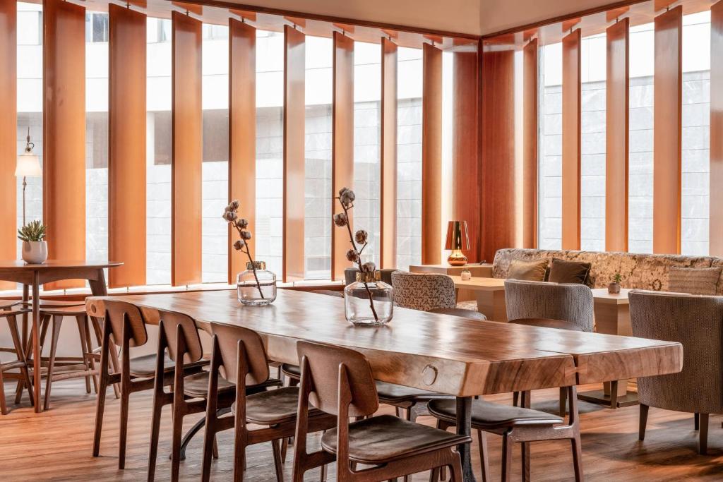 a dining room with a wooden table and chairs at AC Hotel A Coruña by Marriott in A Coruña