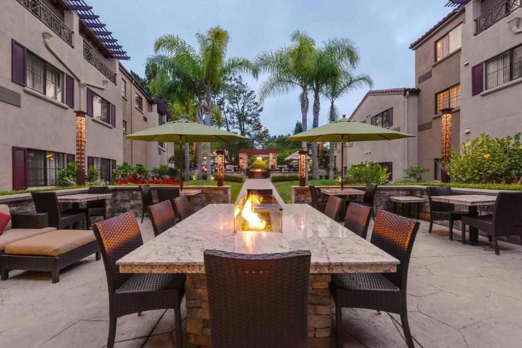 un patio con mesas y sillas y chimenea en Courtyard Palo Alto Los Altos en Palo Alto