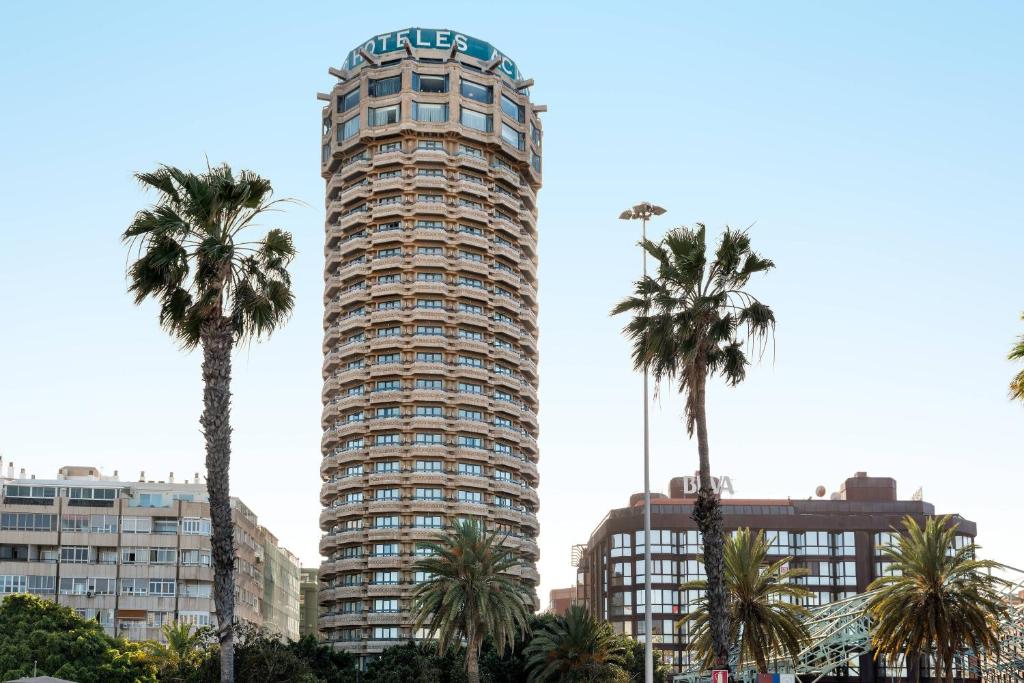 un edificio alto con palmeras delante en AC Hotel Gran Canaria by Marriott, en Las Palmas de Gran Canaria