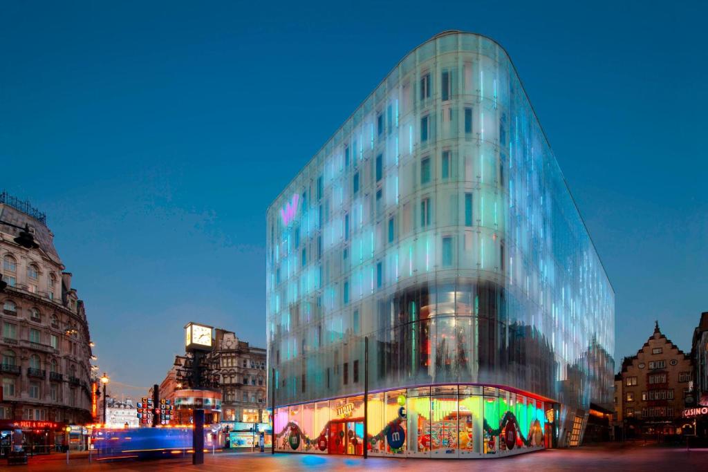 un bâtiment en verre dans une rue de la ville la nuit dans l'établissement W London, à Londres