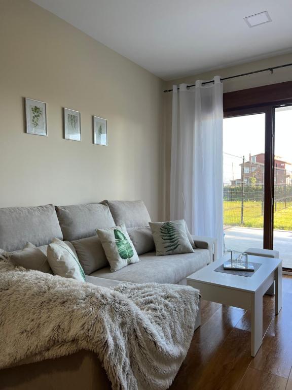 - un salon avec un canapé et une table dans l'établissement Costa Santander. Apartamento con jardín, à Santander