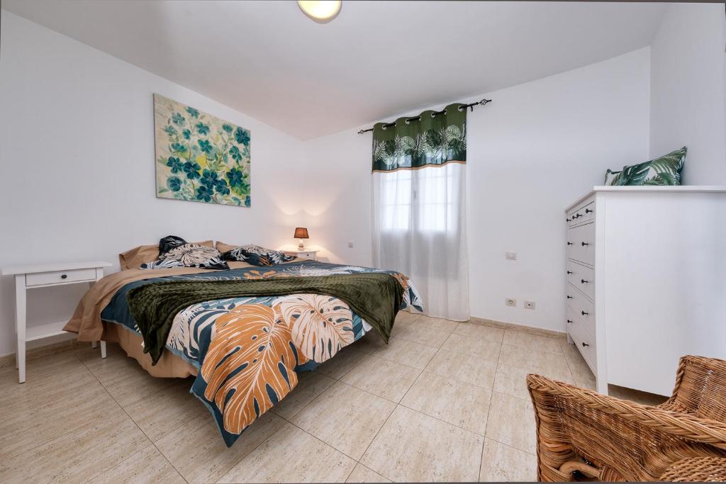 a bedroom with a bed and a dresser and a window at Casa Gemma-quiet and relaxing place in Costa Teguise