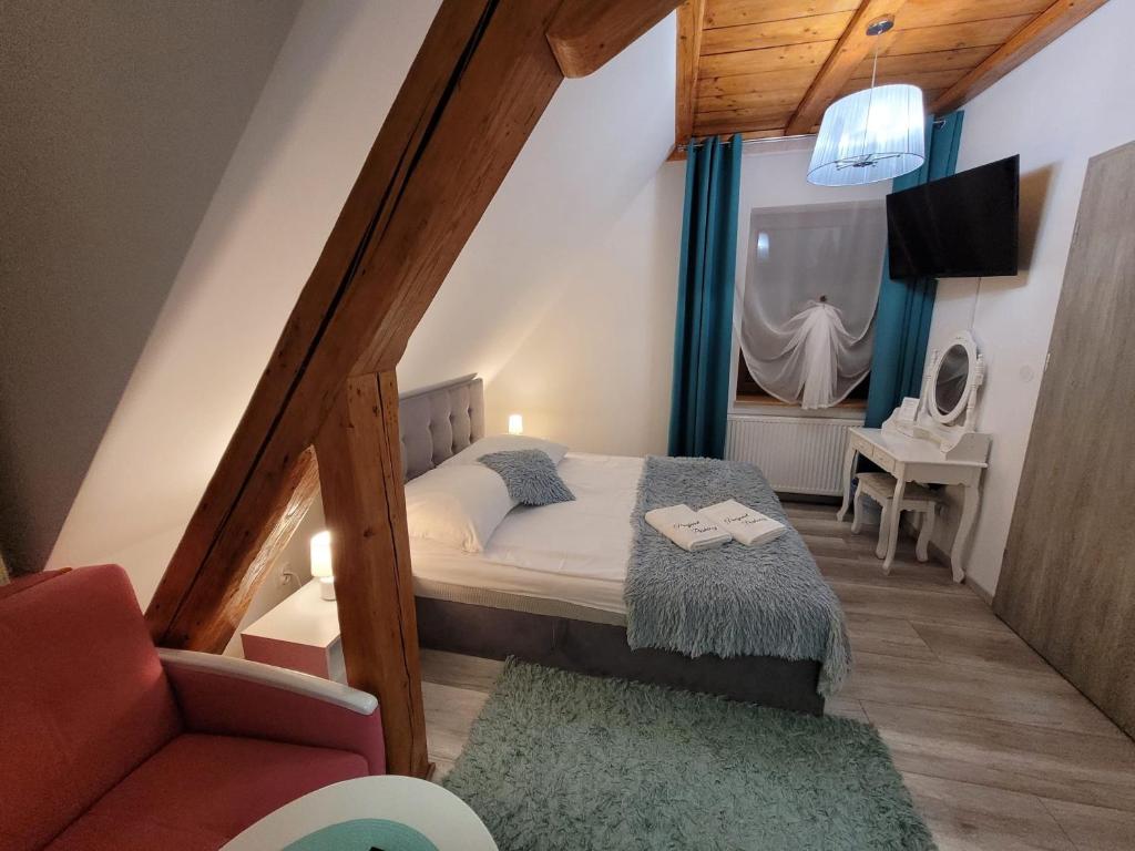 niewielka sypialnia z łóżkiem i krzesłem w obiekcie Parkowy Kudowa w Kudowie Zdroju