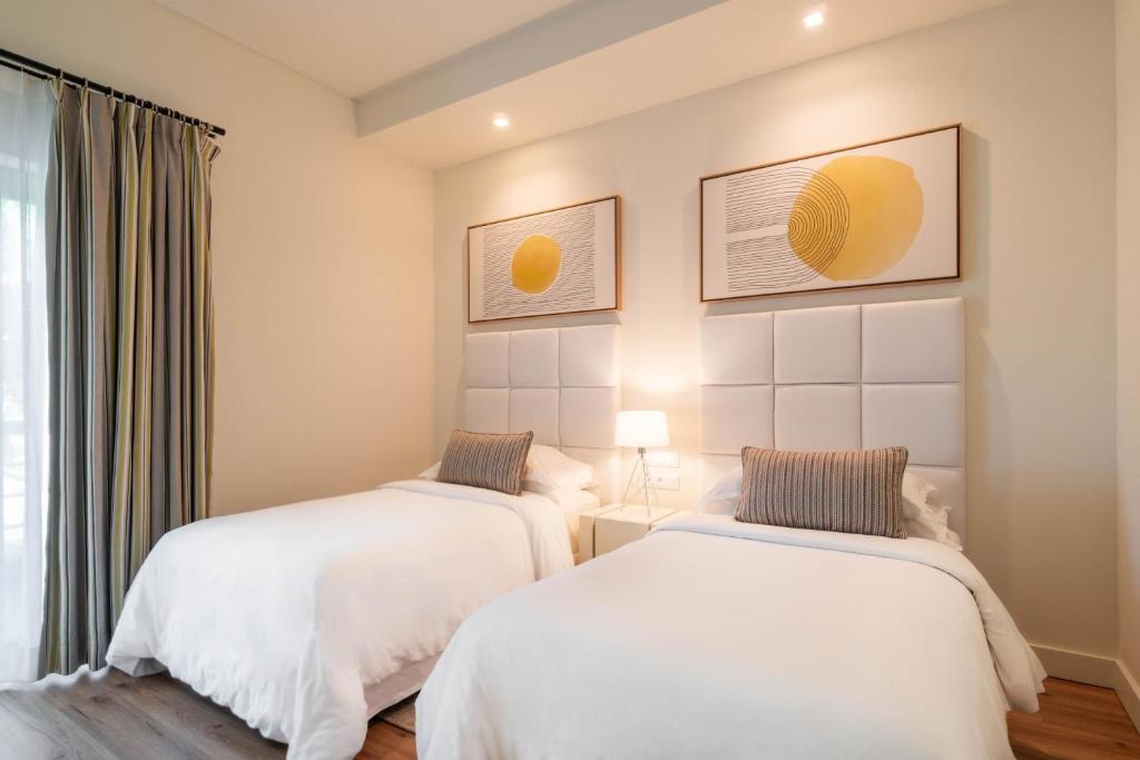 two white beds in a room with a window at Sheraton Cascais Resort - Hotel & Residences in Cascais