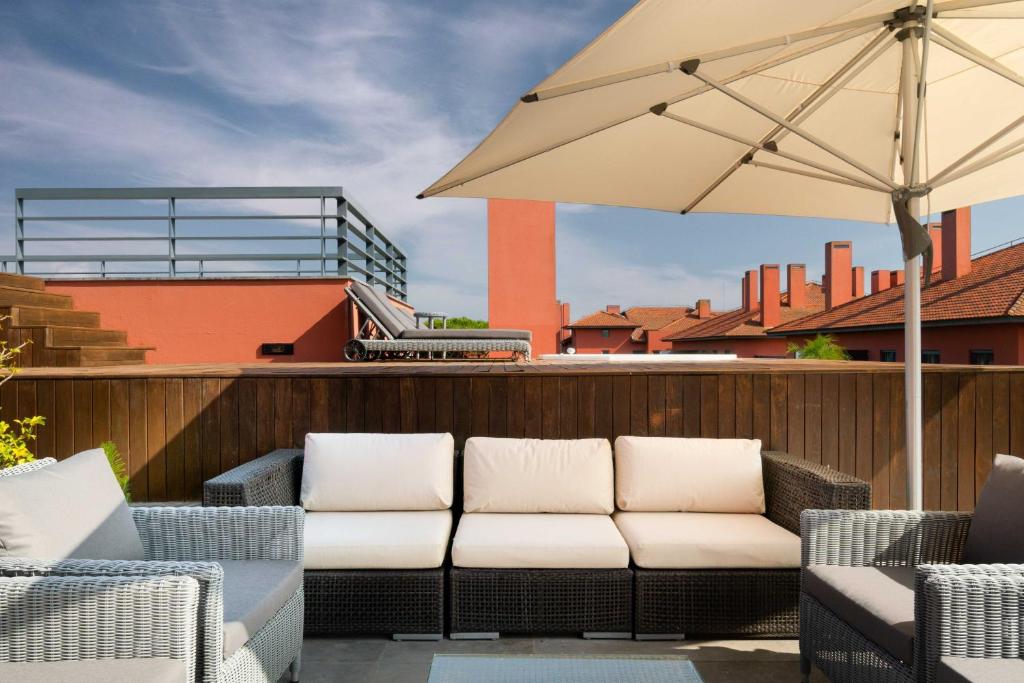 a patio with two chairs and an umbrella at Sheraton Cascais Resort - Hotel & Residences in Cascais
