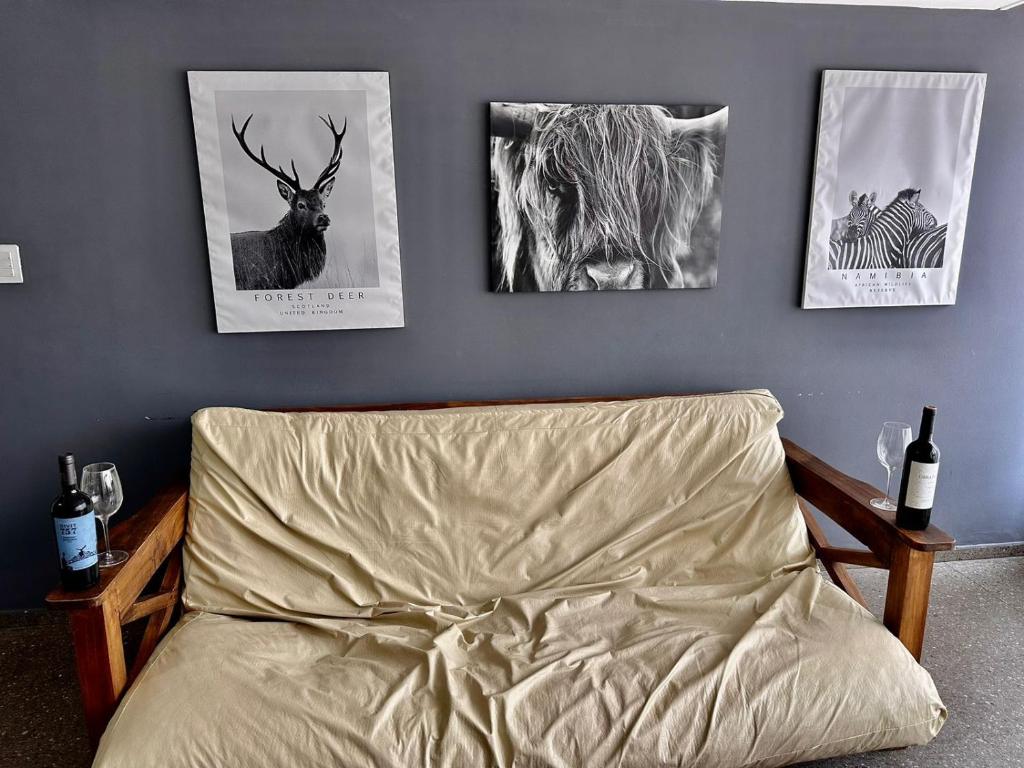 Barraquero的住宿－Vivi Mendoza，卧室配有一张墙上三幅照片的床