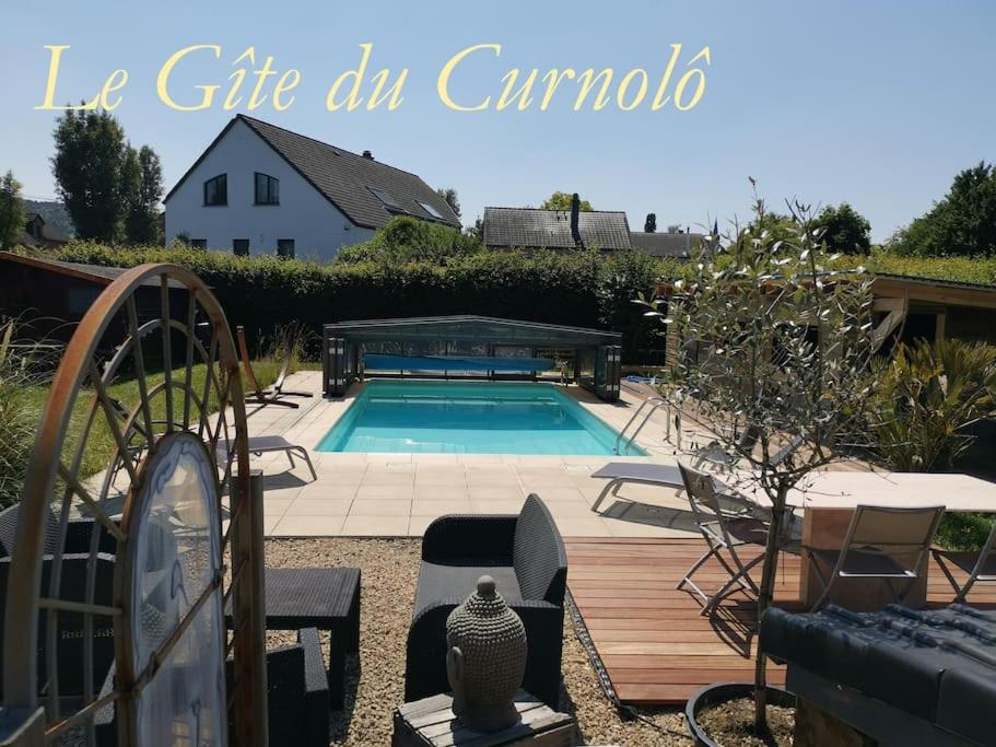a swimming pool in a yard with chairs and a house at Gîte du Curnolo 3* pour 4/6pers avec spa, piscine in Namur