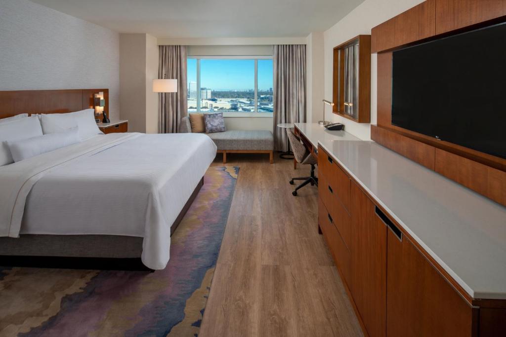 a hotel room with a bed and a flat screen tv at The Westin Houston, Memorial City in Houston