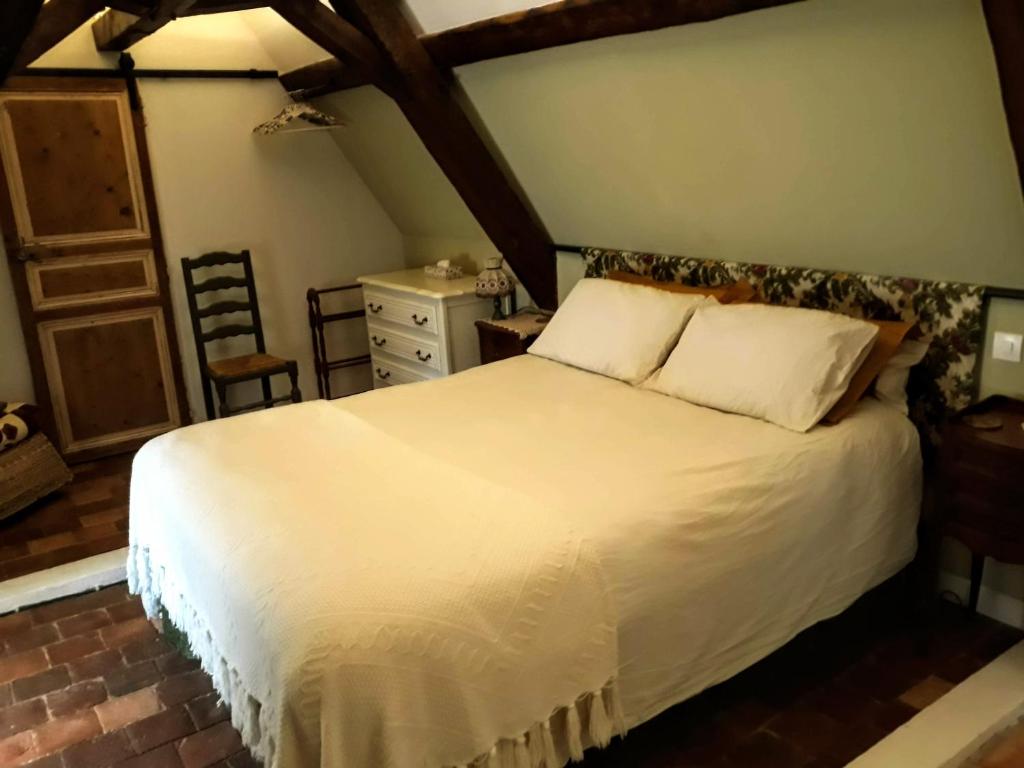 ArmailléにあるLes Hirondelles B&Bのベッドルーム(白いベッド1台、椅子付)