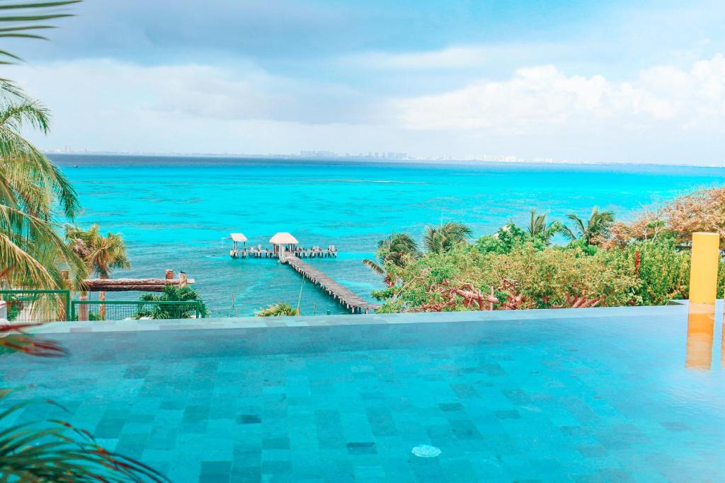 a swimming pool with a view of the ocean at Casa de los Sueños Hotel Boutique in Isla Mujeres