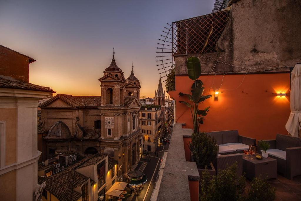 a view of a city at sunset from a balcony at Piazza di Spagna Comfort Rooms in Rome