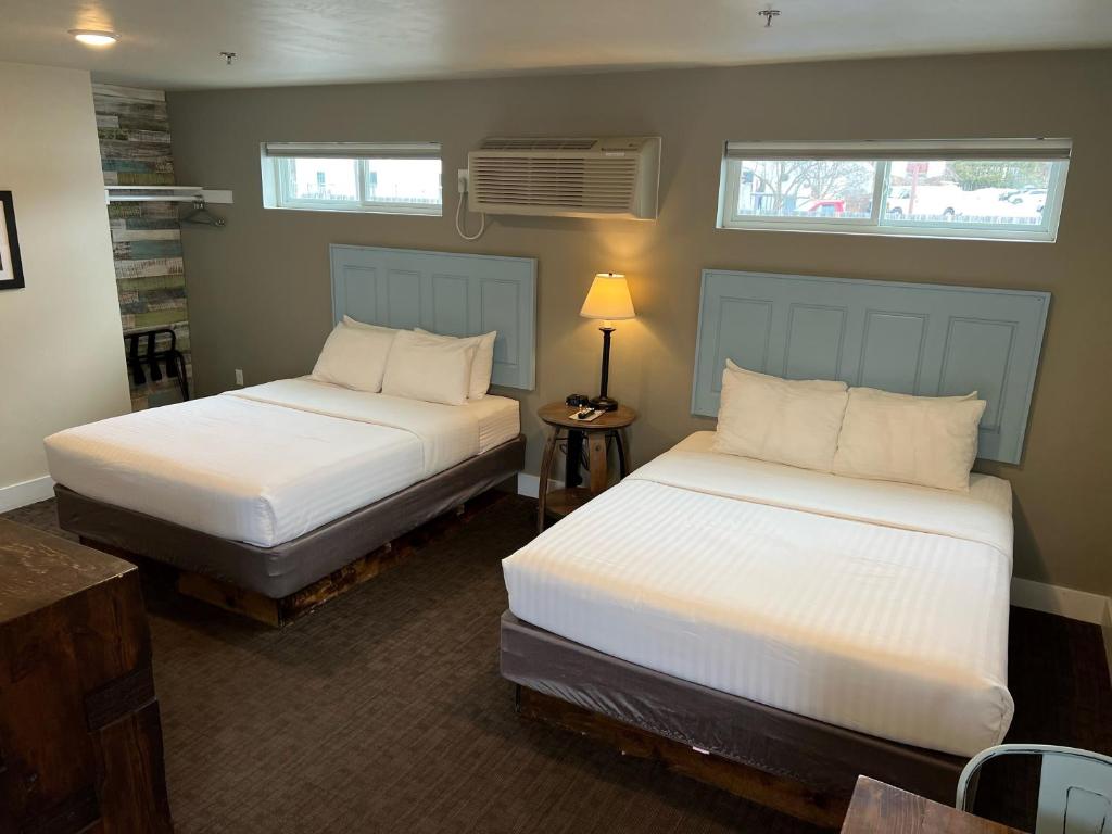 two beds in a room with two windows at Julie's Park Cafe & Motel in Fish Creek