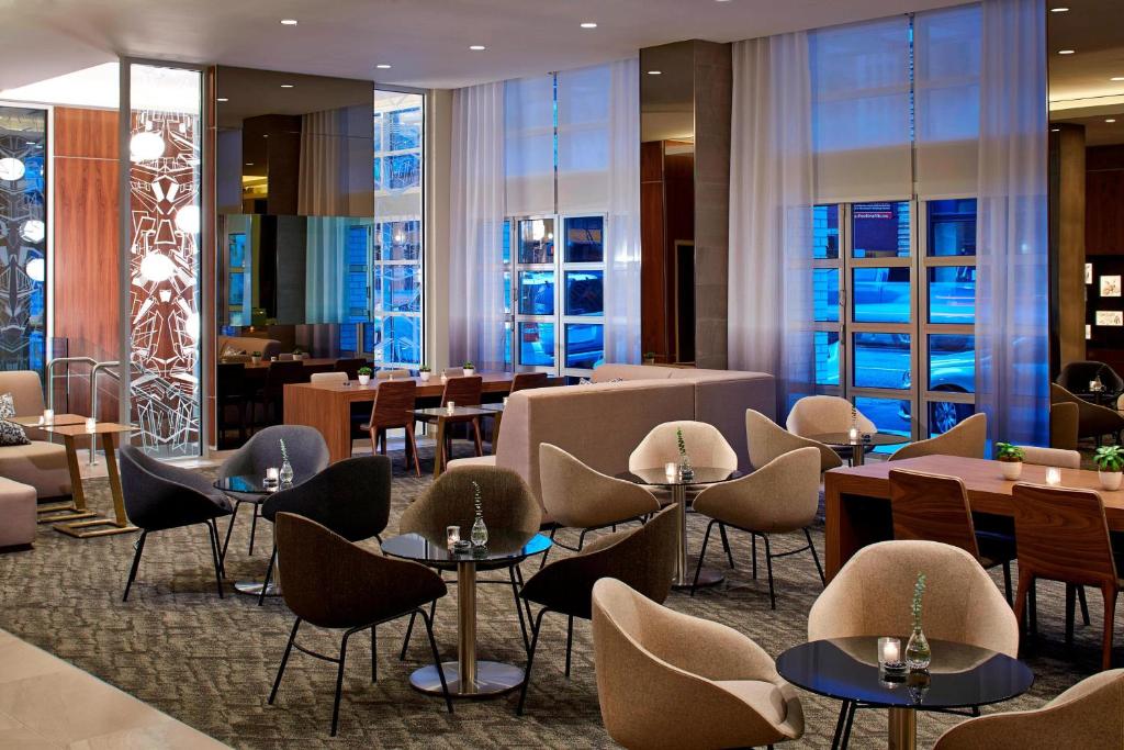 a restaurant with tables and chairs and windows at AC Hotel by Marriott Portland Downtown, OR in Portland