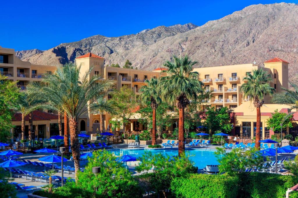 a resort with a pool and palm trees and a mountain at Renaissance Palm Springs Hotel in Palm Springs