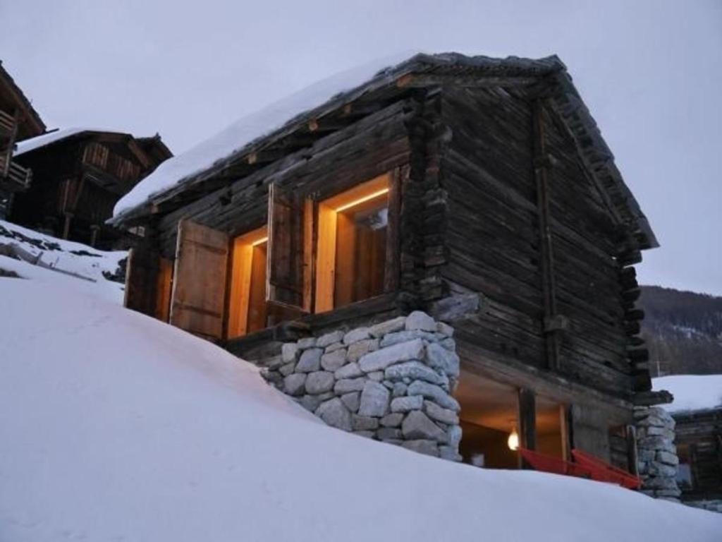 a log cabin with a pile of snow in front of it at Mayen à Jean in Haudères