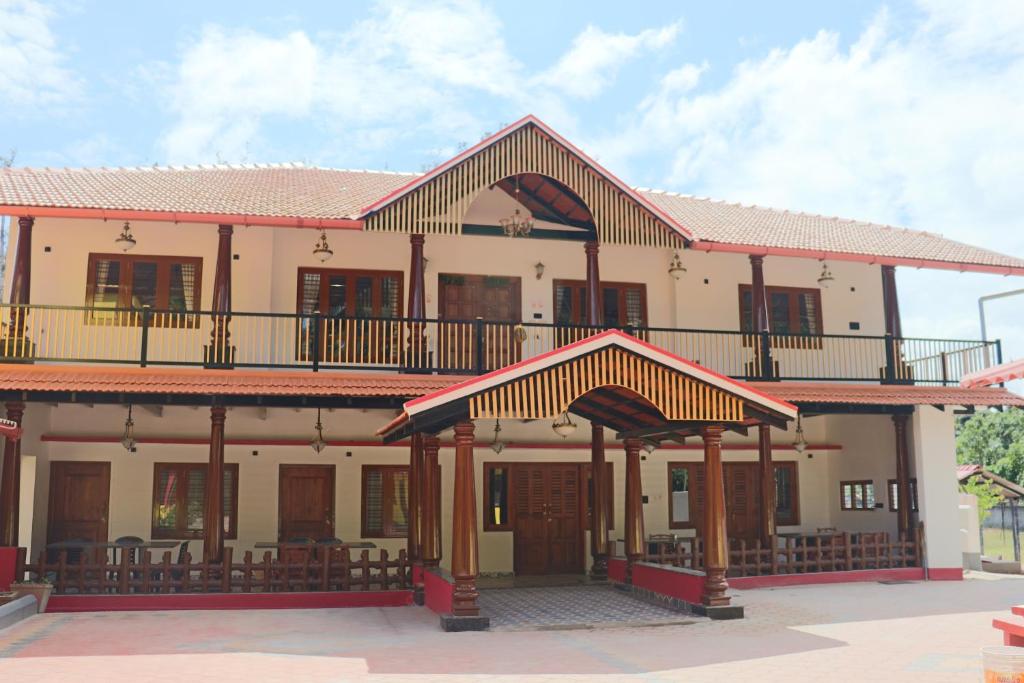 an old house with a balcony on top of it at Taniva Dani by CoffeeBeanVilla in Sakleshpur