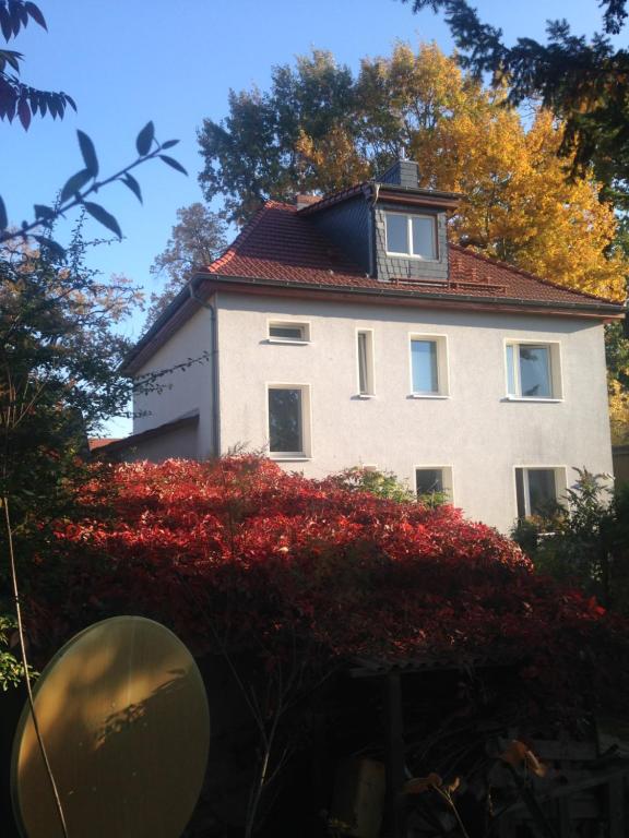 Ferienwohnung Heil - Königs Wusterhausen في كونيغز فوسترهاوزن: بيت ابيض كبير بسقف احمر