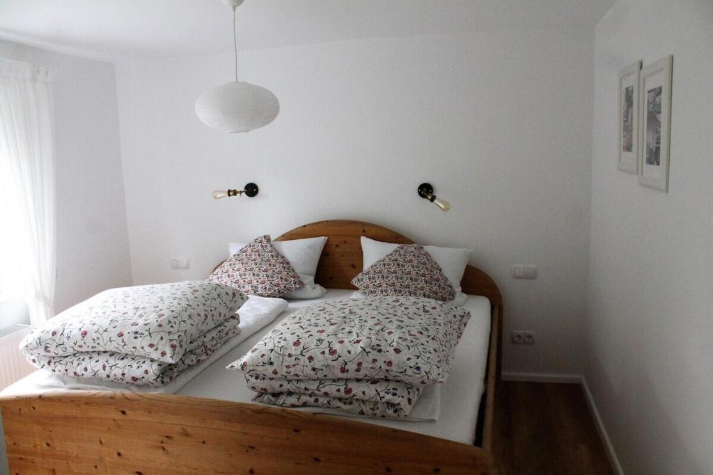 um quarto com uma cama de madeira com almofadas em Appartement Gensungen em Felsberg