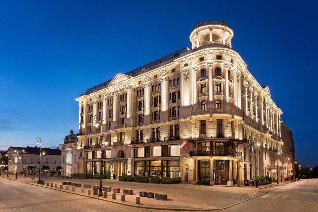 a large white building on a street at night at Hotel Bristol, A Luxury Collection Hotel, Warsaw in Warsaw